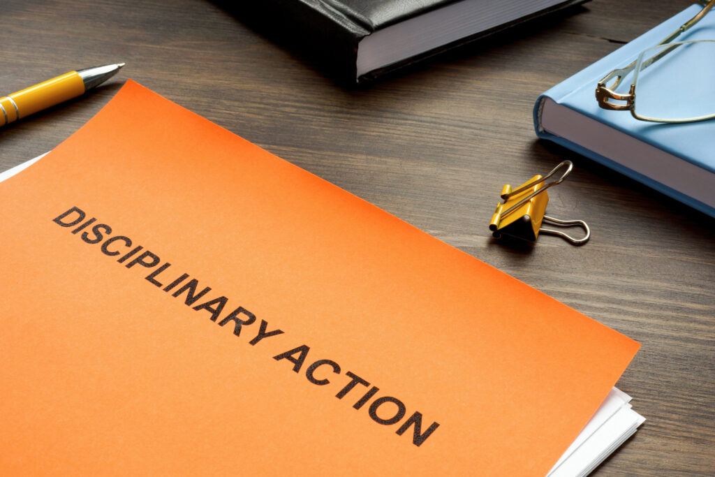 Disciplinary action documents labeled on orange folder 